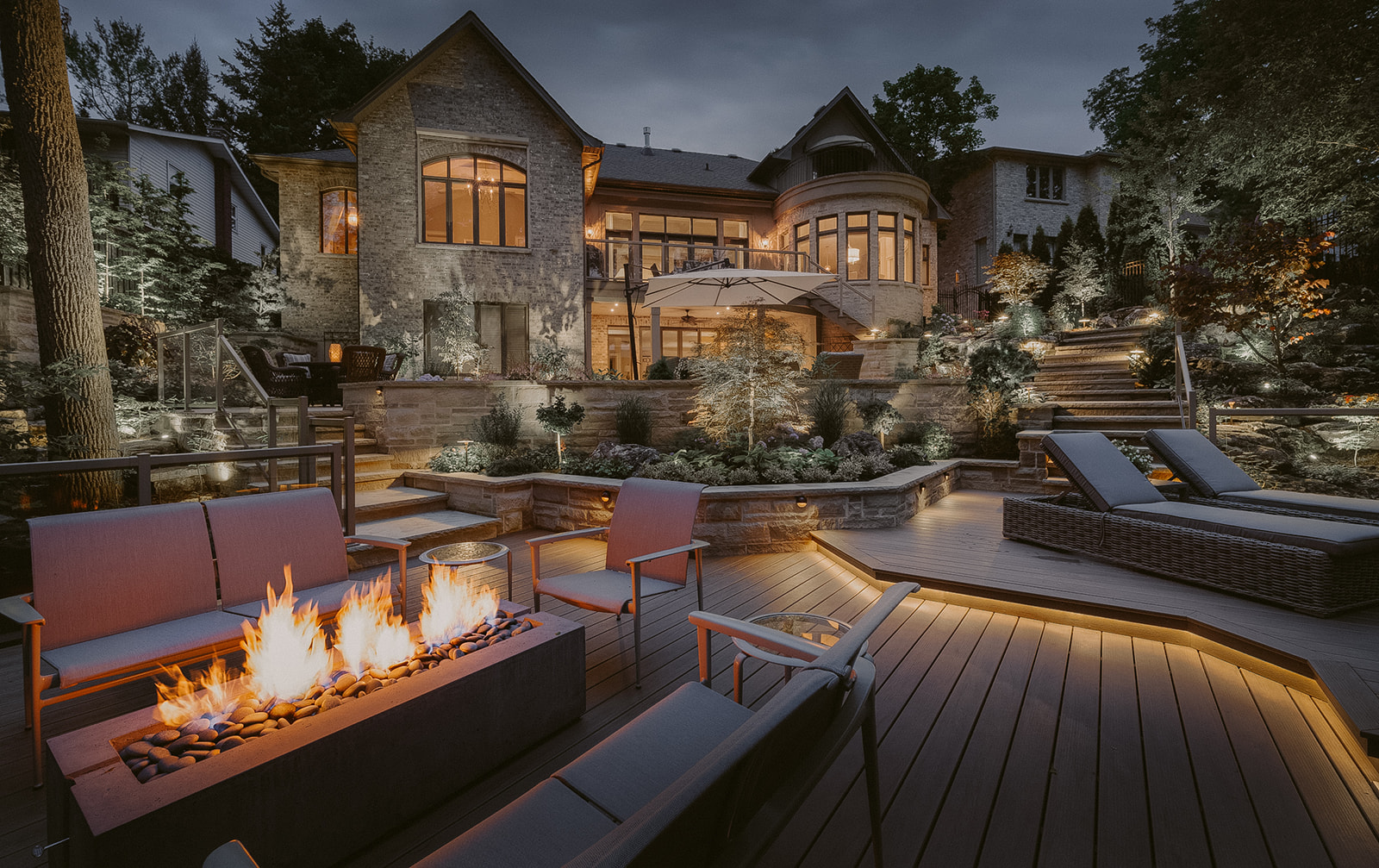 Grand outdoor living area enhanced by a glowing Dekko firepit, setting a welcoming tone for entertainment and cozy gatherings.