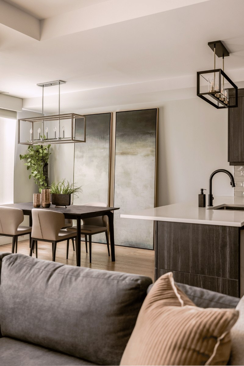 Contemporary dining room with moody abstract artwork, black dining table, and soft taupe chairs in the Harbour Club condo.