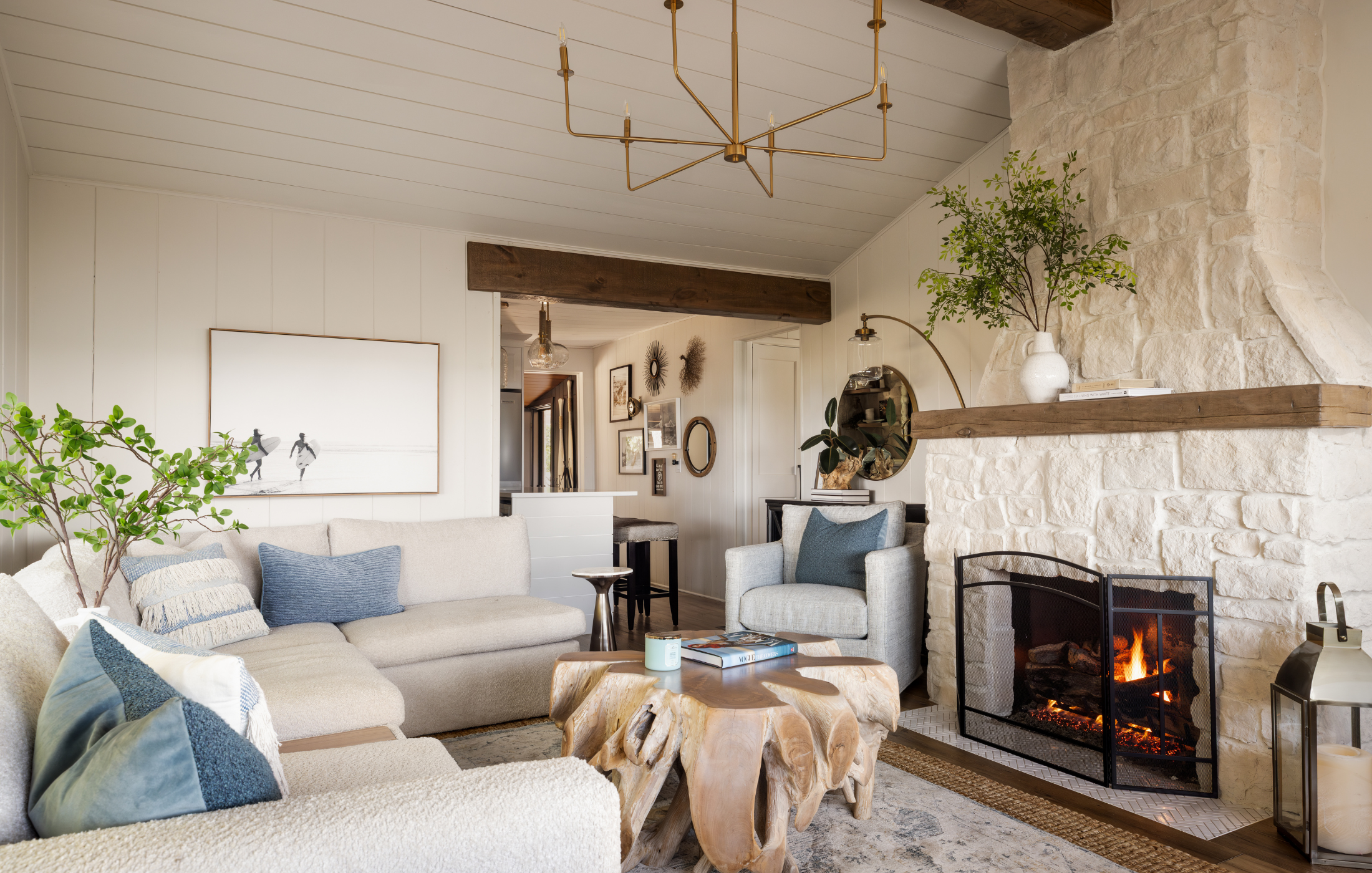 Cozy lakehouse living space with stone fireplace, sectional sofa, and warm wood accents.